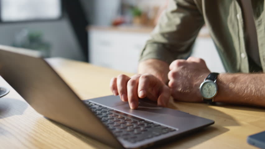 Girlfriend carrying coffee to boyfriend looking laptop in kitchen closeup. Man kissing smiling woman drinking beverage hurrying to office work. Happy wife giving croisson to husband hastening to job.