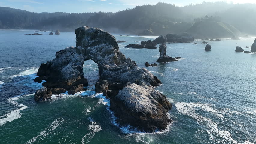 The Pacific Ocean surrounds rugged sea stacks found just off the scenic coast of northern Oregon near Cannon Beach. This beautiful area is a popular destination during summer months.
