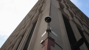 This image shows a surveillance camera on a modern building corner, highlighting the essential security features of contemporary urban architecture, captured from a striking highangle view - Powered by Shutterstock - Get 15% off with code: PIKWIZARD15