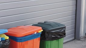 Waste management worker sorting recyclables in colorful bins at a municipal facility in the afternoon - Powered by Shutterstock - Get 15% off with code: PIKWIZARD15