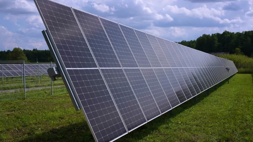 Solar panels with active tracker. PV panels tracking sun timelapse. Modern technology, renevable energy, solar panels moving towards sun, rural landscape	