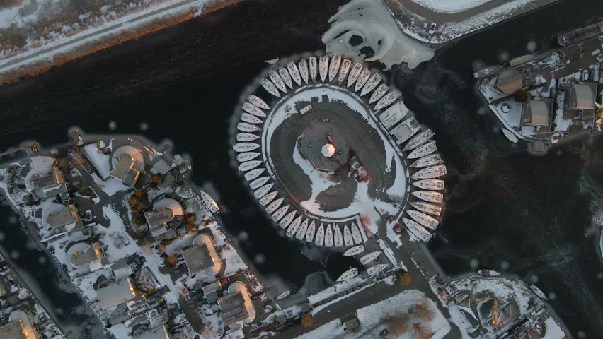 Aerial view of snowy village with frozen canal and boats, Lemmer, Friesland, Netherlands.
