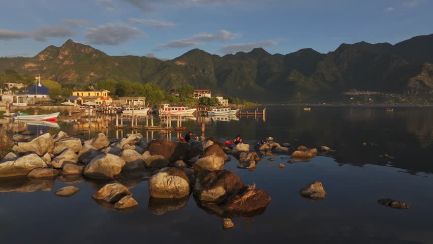 Aerial view of Lake Atitlan at sunrise with locals cleaning clothes, San Pedro La Laguna, Guatemala.