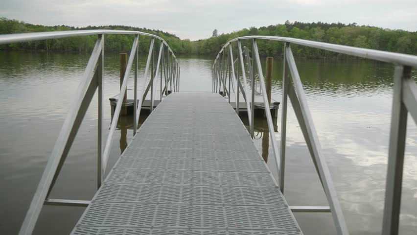 Afternoon walk on an empty boat dock on the lake while a fishing boat passes in the background. Lake Murray in South Carolina.