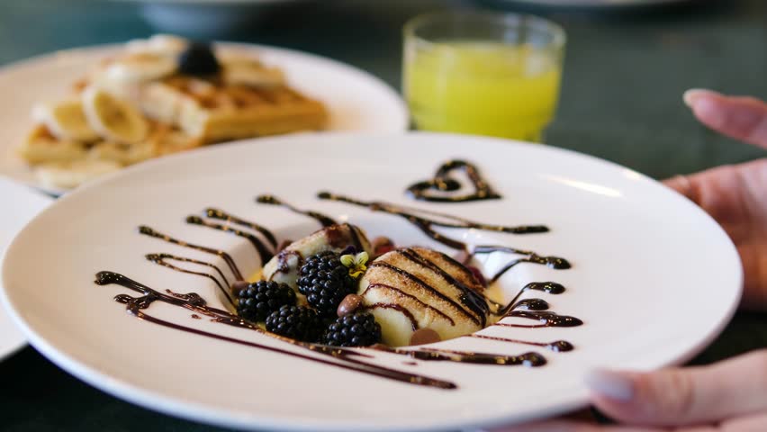 Close up view of syrniki syrniki, cottage cheese pancakes with berries and chocolate cream on white ceramic plate. Delicious healthy breakfast, snack or lunch.