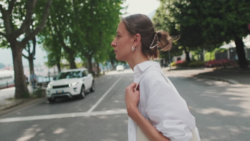 A young woman crosses the road at pedestrian crossing