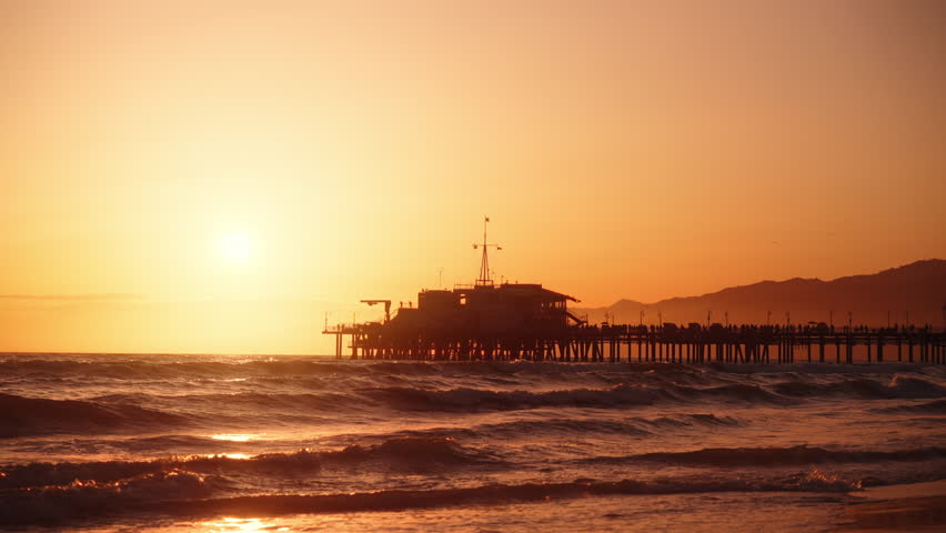 View of Santa Monica pier from Venice beach during a beautiful sunset in Los Angeles, California, USA