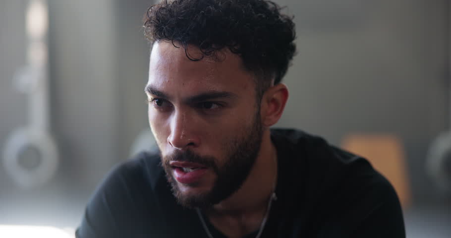 Breathing, exercise and sweat with man in gym for intense challenge, performance or workout. Fitness, training and wipe with exhausted athlete person in health club for break, recovery or rest