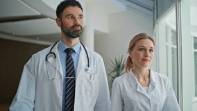 Confident doctors going hospital looking camera. Closeup smiling professionals working walking in modern healthcare clinic together. Friendly medical experts posing with stethoscope in white coats. - Powered by Shutterstock - Get 15% off with code: PIKWIZARD15