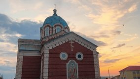 Panoramic view of a moving camera around an Orthodox Christian church, during the evening sunset, with birds flying low around it. - Powered by Shutterstock - Get 15% off with code: PIKWIZARD15