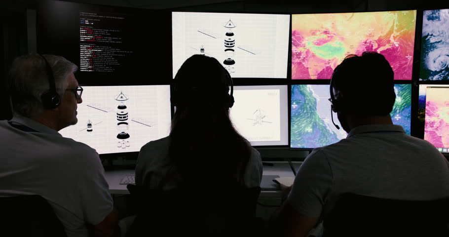 People, control room and team monitor weather pattern on satellite maps to track storm with back. Meteorologist, climate scientist or group on screen with code for global warming at night on overtime