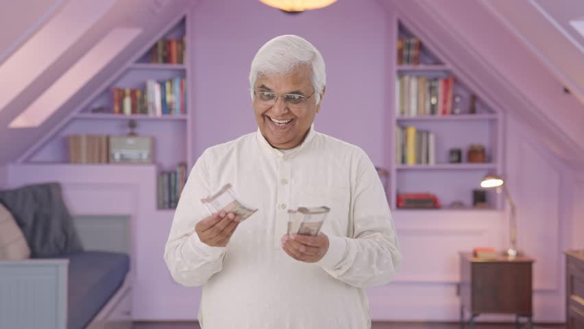Cheerful Indian old man counting money