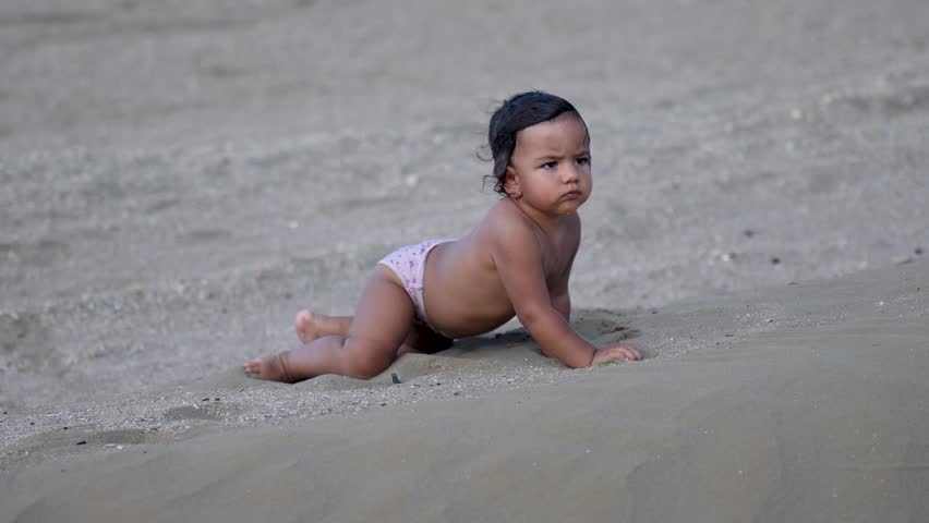 Cute baby girl walking on sandy beach. Little girl playing at beach enjoyin..