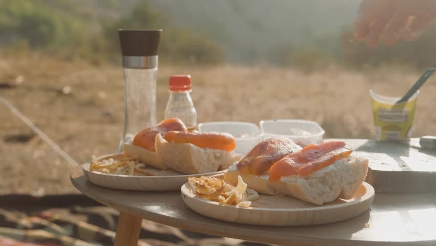 Enjoy a delicious camping meal featuring savory sandwiches accompanied by tasty snacks