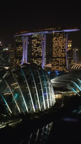 Marina Bay Sands hotel, Flower Dome, Cloud Forest, night drone shot, Singapore, vertical video.