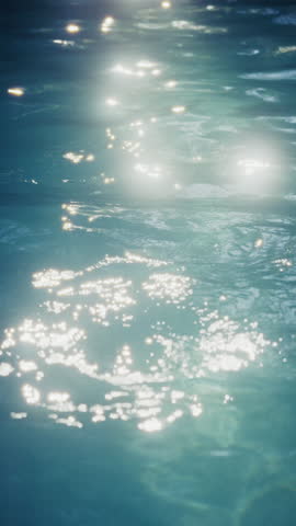 A close-up view of a blue pool shimmering with glittering sun reflections