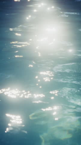 A close-up view of a blue pool shimmering with glittering sun reflections