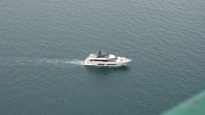 Yacht sails in tranquil sea lagoon on summer day slow motion. Modern motorboat in azure ocean water. Luxury marine cruise by comfortable vehicle