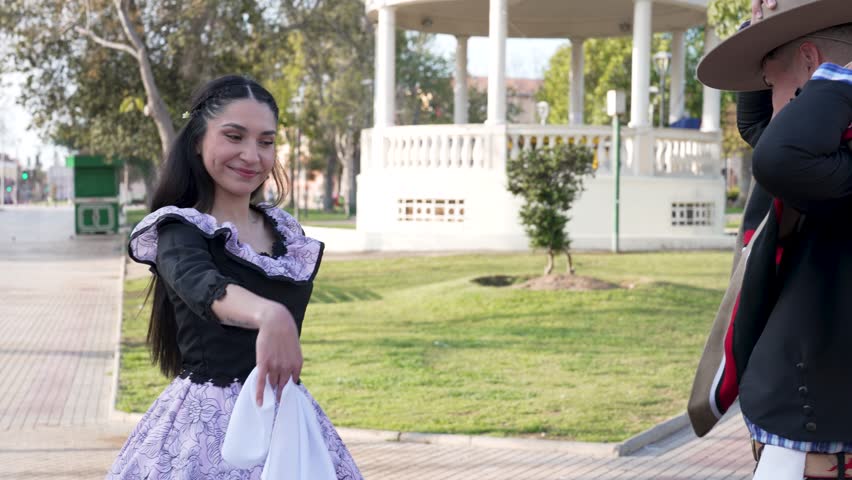 couple of huasos dancing Chilean cueca in the city square, Fiestas Patrias concept