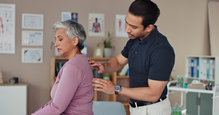 Back pain, physiotherapy and advice with man in office for rehabilitation, orthopedic consulting or spinal injury. Healthcare, wellness and medical with senior patient for muscle recovery and healing