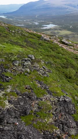 Vertical Norway hiking trail Knutshoe aerial reveal with lake