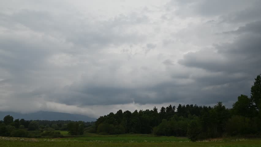 Timelapse of a storm forming over trees.