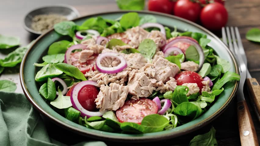 Canned tuna salad with tomatoes lambs lettuce corn salad and onions, stock video 4k