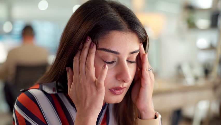 Headache, woman or tired in office for finance, company debt and burnout in business. Female administrator, frustrated or anxiety in workplace for budget crisis, stress or massage temples for relief