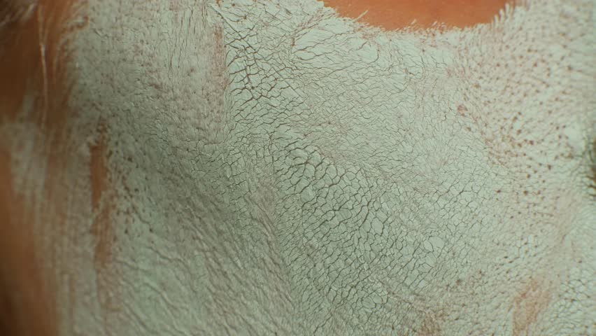 Woman takes care of the skin of the face with a mask. close up of the texture of the blue clay face mask. Lady feels residue of natural extracts working to improve skin tone and texture