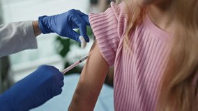 Hands giving immunization injection to cute girl closeup. Pretty child visiting pediatrician in clinic. Unknown healthcare worker nurse performing vaccination shot with syringe in childcare facility. - Powered by Shutterstock - Get 15% off with code: PIKWIZARD15