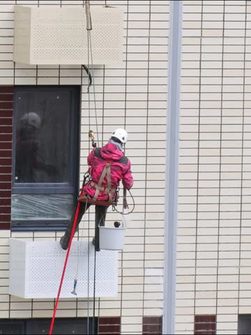 Window washing in a building at high altitude by an industrial alpenist.