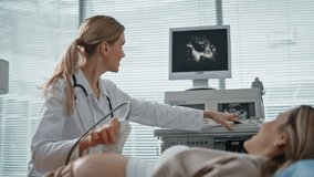 Gynecologist performing sonogram examination closeup. Happy doctor showing baby on monitor using ultrasound machine in healthcare clinic. Professional doctor consulting during prenatal health checkup. - Powered by Shutterstock - Get 15% off with code: PIKWIZARD15