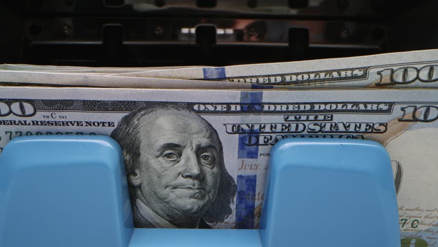 Counting cash in a bustling bank while handling multiple transactions in the city during working hours