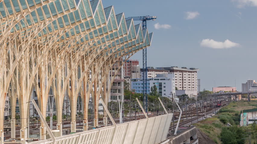 Lisbon Oriente Train and Bus Station aerial timelapse where steel and glass trees interlock to form a continuous system of transparent roofs. Trains arrive and departure. Lisbon, Portugal