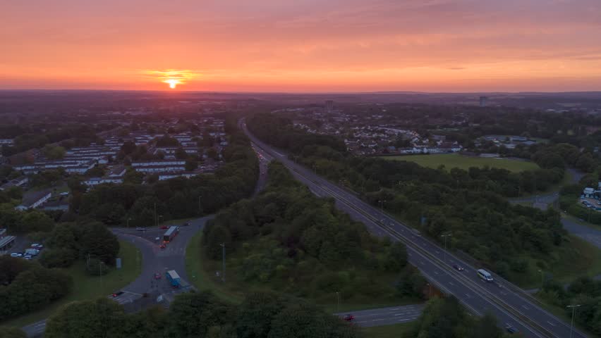 Aerial view of busy dual carigeway in Basingstoke Hampshire UK during early morning rush hour with sunrise in background
