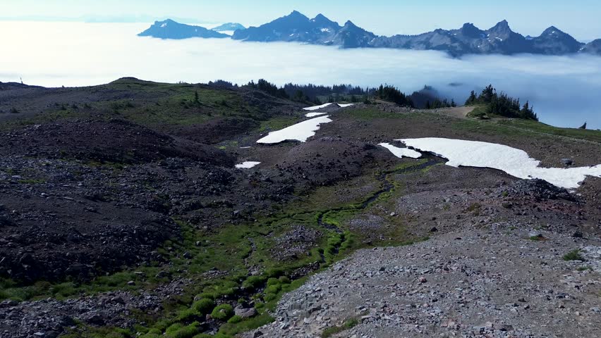 Mount Rainier ice glacier rocky mountain range hiking trails path with hazy fog clouds over mountaintop region Seattle Washington national parks USA America travel tourism