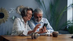 elderly people sitting at a table together watching social networks on the phone funny videos happy old age elderly couple pleasant memories leisure time in old age warm feelings support in old age - Powered by Shutterstock - Get 15% off with code: PIKWIZARD15