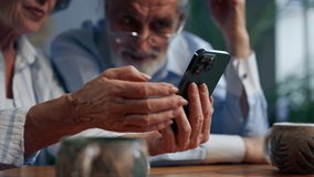 close up elderly people sitting at a table together watching social networks on the phone funny videos happy old age elderly couple pleasant memories leisure time in old age warm feelings support in - Powered by Shutterstock - Get 15% off with code: PIKWIZARD15
