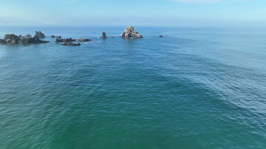 The rarely calm Pacific Ocean surrounds rugged sea stacks found just off the scenic coast of northern Oregon near Cannon Beach. This beautiful area is a popular destination during summer months.