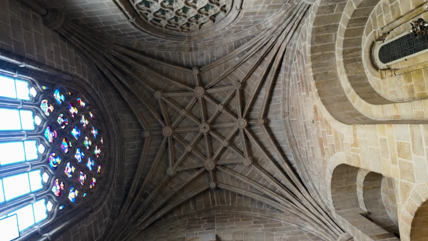Upward orbit of interior of tower inside of ceiling with geometric designed stone supporting tower, Cathedral of San Martin de Ourense, Galicia Spain