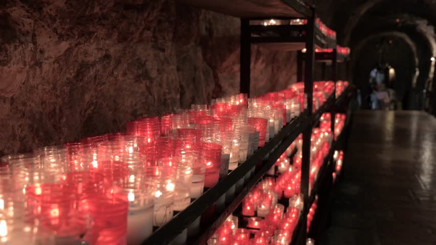 White and red candles lighted for the petitions of the faithful in the Holy Cave of the Virgin of Covadonga