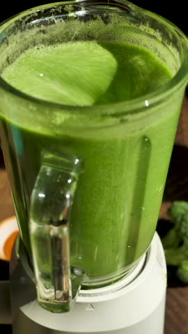 Vertical: Blending green vegetable smoothie with a blender. Make green leafy vegetable smoothie for drinking. Vegetarian spinach and broccoli smoothie with spices. Healthy lifestyle