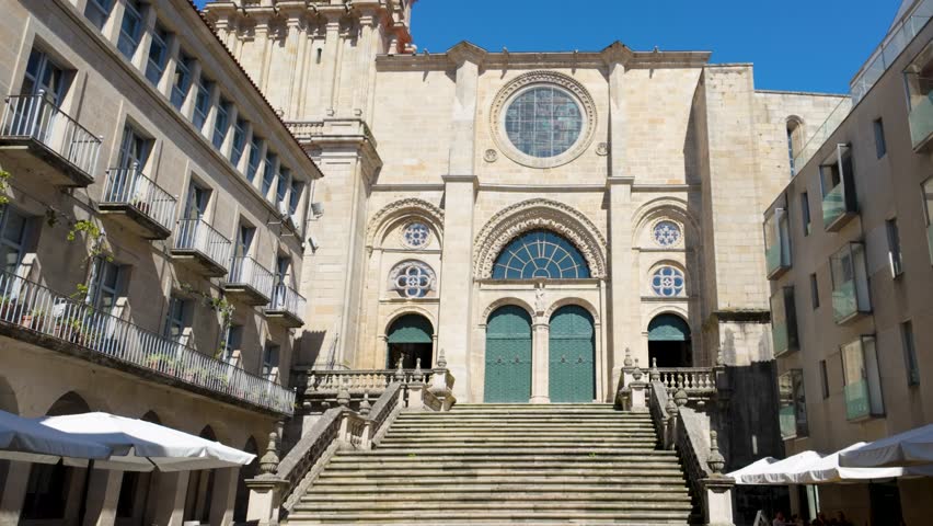 Tilt up exterior edge of Cathedral of San Martin de Ourense, Galicia Spain with stained glass windows and blue sky