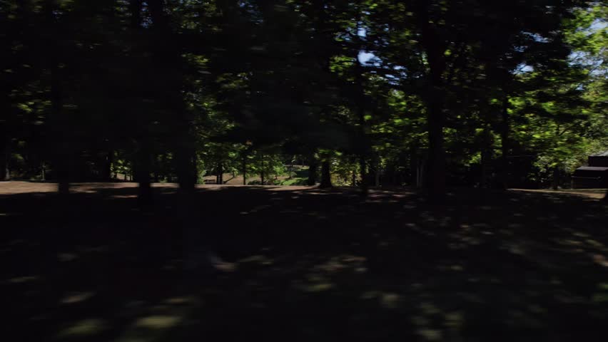 Moving past American homes in central Ohio in the midwest, United States on a bright and dry summer day through Columbus neighborhood with houses, buildings, traffic, businesses, and other buildings