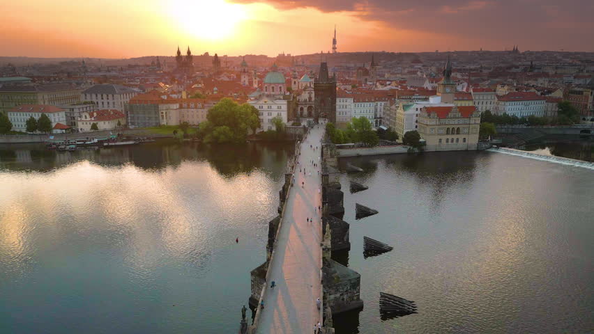 Prague city skyline aerial top view fly ove prague charles bridge at sunset, in front bridge cathedral church and river beautiful sunrise over old town. Czech Republic city.