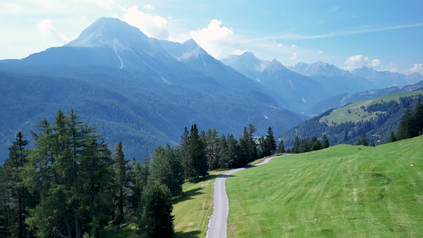 Exploring the breathtaking alpine landscape near Innsbruck, including winding roads and lush green fields during a sunny afternoon