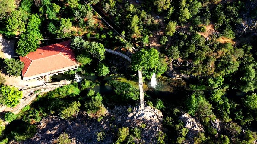 A waterfall flowing in magnificent nature on a high mountain peak among green trees, ice cold water, the peaceful sound of water flowing from the waterfall.A wonderful holiday destination for the week