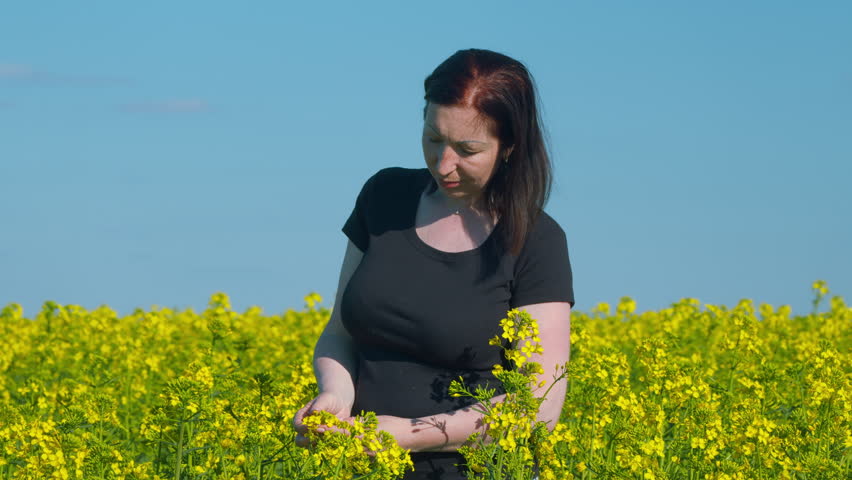 Elegant Girl In Countryside Nature Place. Agricultural Yellow Flowering Rapeseed. Yellow Flowers And Happy Caucasian Woman.