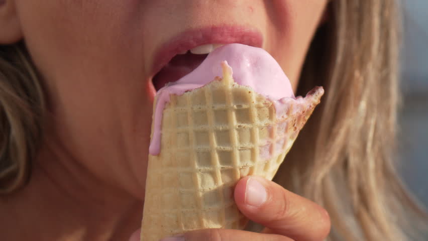 Woman Ice Cream Cone Licking Summer Treat, A woman licks an ice cream cone with her tongue.