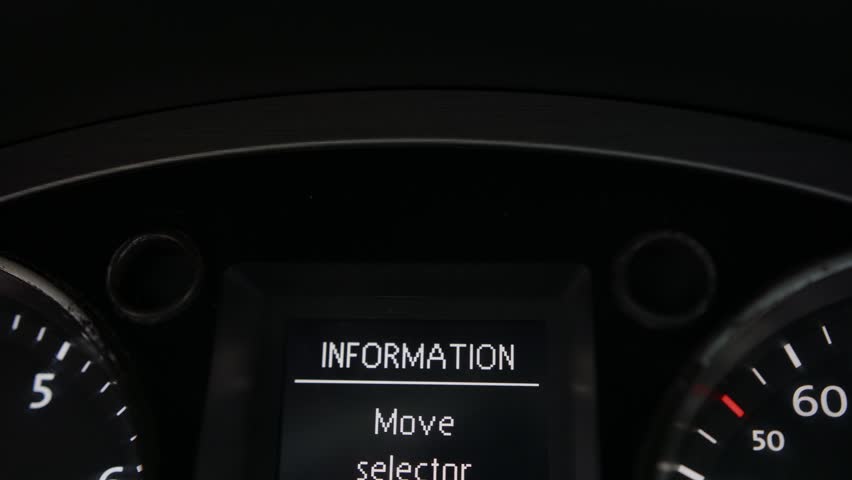 Car dashboard close-up. A green turn signal light of a car